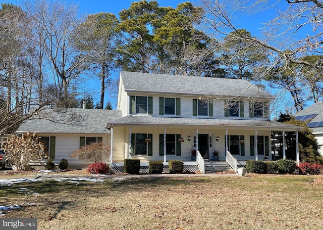 view of front of house featuring covered porch and a front lawn