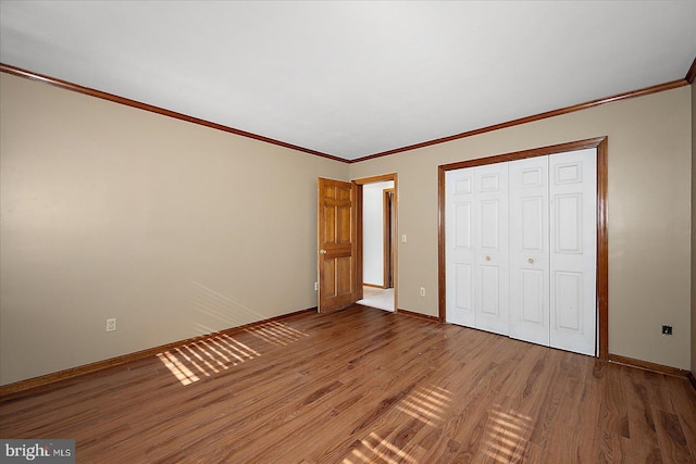 10133 Queens Cir, Ocean City, MD 21842 - unfurnished bedroom featuring a closet, crown molding, light wood-style floors, and baseboards