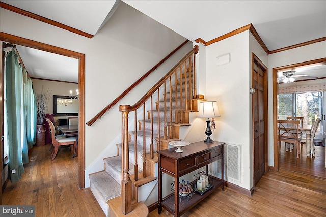 10133 Queens Cir, Ocean City, MD 21842 - staircase featuring baseboards, visible vents, crown molding, and wood finished floors