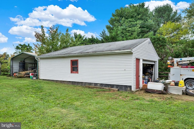 garage with a carport and a yard