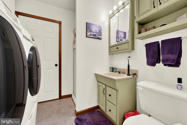 bathroom with vanity, toilet, and washer / dryer