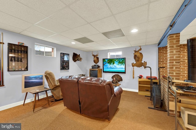 living room featuring a healthy amount of sunlight, carpet, and a drop ceiling