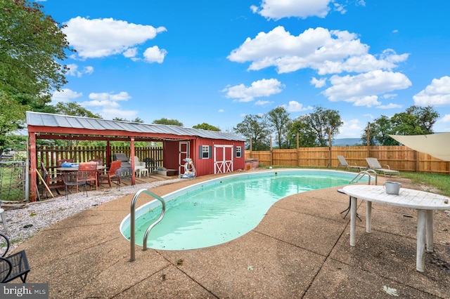 view of swimming pool with an outbuilding and a patio