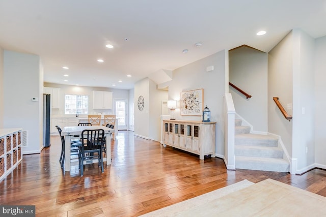 dining space with baseboards, stairway, wood finished floors, and recessed lighting