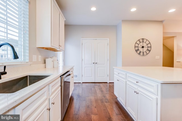 kitchen with dark wood-style flooring, a sink, white cabinetry, stainless steel dishwasher, and recessed lighting