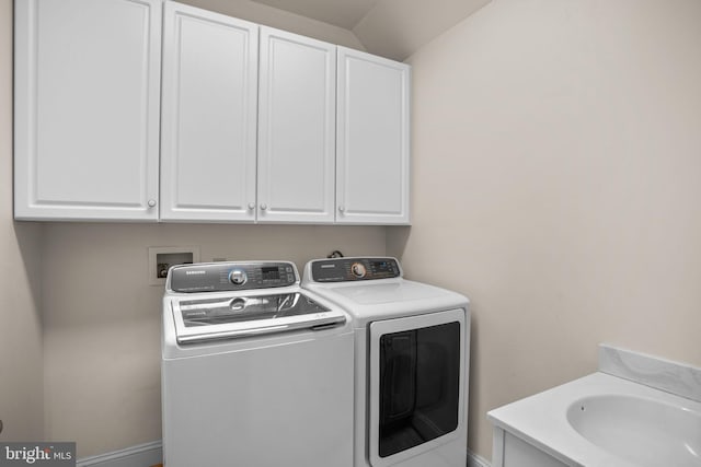 laundry room featuring washer and clothes dryer, cabinet space, and a sink