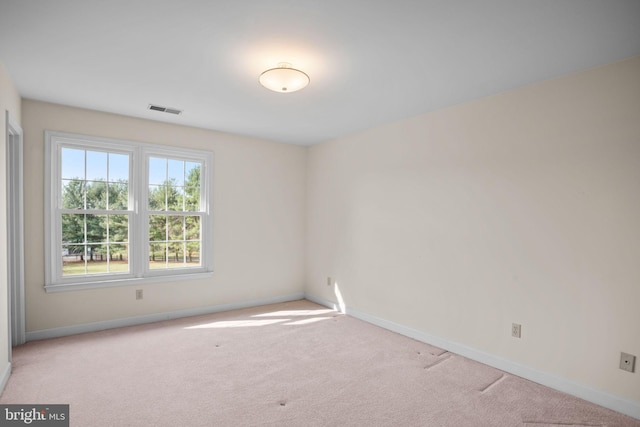 unfurnished room with visible vents, baseboards, and carpet