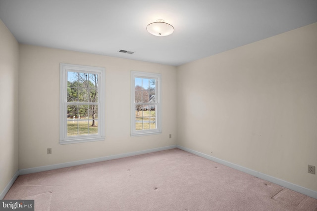 empty room with light colored carpet, visible vents, and baseboards