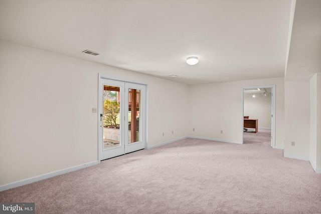 spare room featuring visible vents, baseboards, and light colored carpet