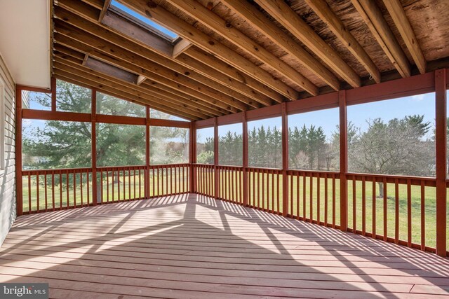 unfurnished sunroom featuring a skylight