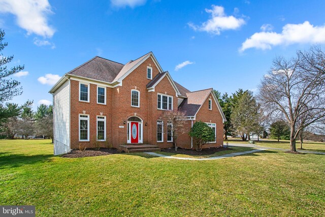 view of front of property with a front lawn and brick siding