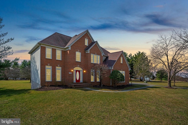 view of front facade featuring brick siding and a front lawn