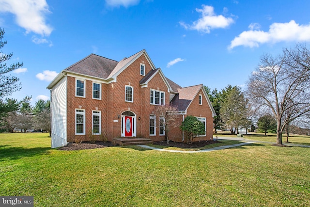 view of front facade with brick siding and a front lawn