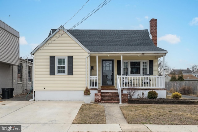 bungalow-style home featuring covered porch and a front lawn