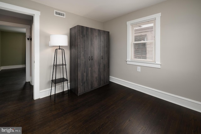 unfurnished bedroom with dark hardwood / wood-style floors