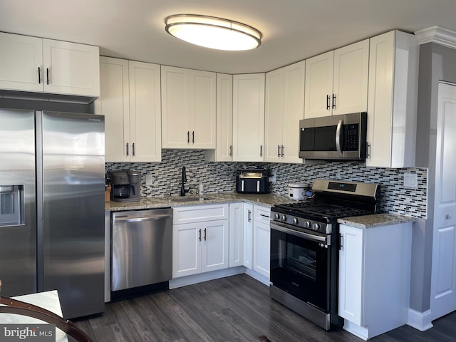 kitchen featuring white cabinets, stainless steel appliances, light stone countertops, and sink