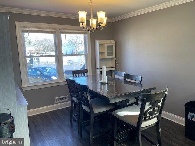 dining area featuring ornamental molding, dark wood-type flooring, and an inviting chandelier