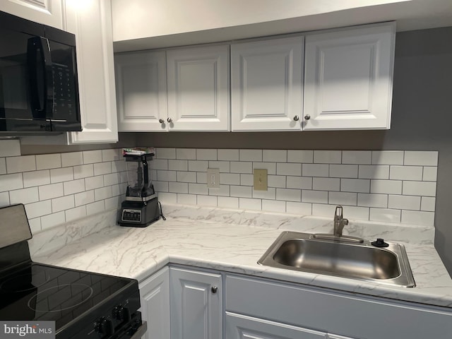 kitchen featuring sink, electric range oven, white cabinetry, and backsplash