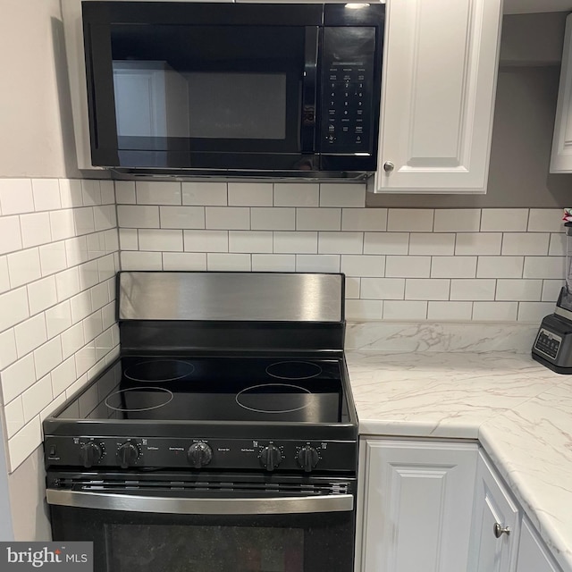 kitchen featuring electric stove, backsplash, white cabinets, and light stone countertops