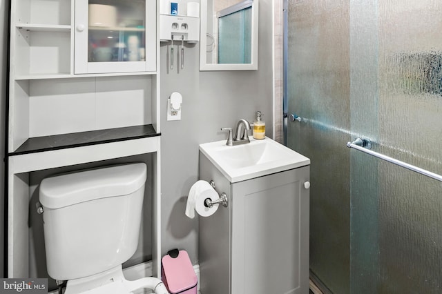 bathroom featuring an enclosed shower, vanity, and toilet