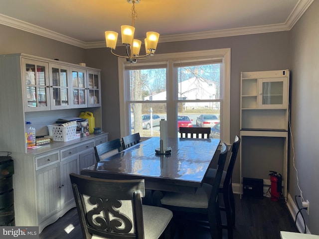 dining space with ornamental molding, dark hardwood / wood-style floors, and a notable chandelier