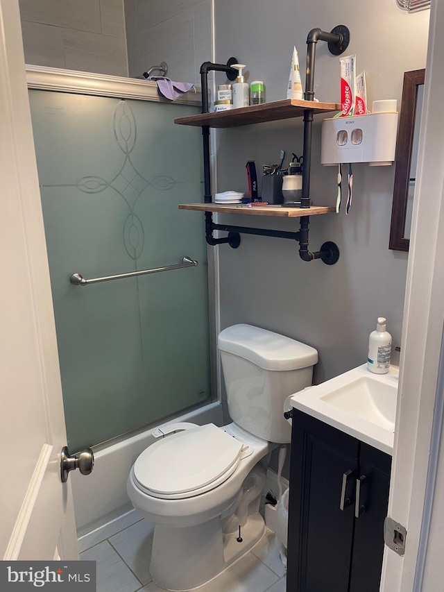 full bathroom featuring tile patterned floors, vanity, combined bath / shower with glass door, and toilet