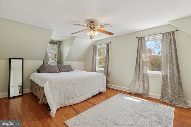 bedroom with baseboards, ceiling fan, vaulted ceiling, and wood finished floors