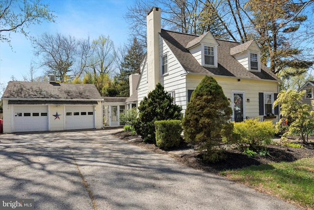 view of home's exterior with a chimney and driveway