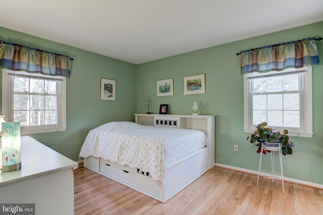 bedroom featuring light hardwood / wood-style flooring and multiple windows