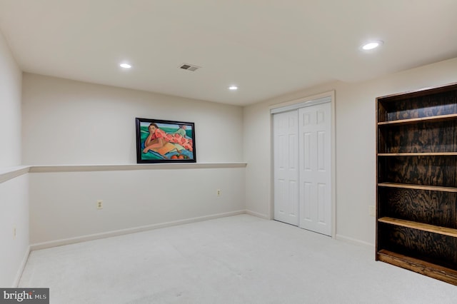 unfurnished bedroom featuring light carpet and a closet