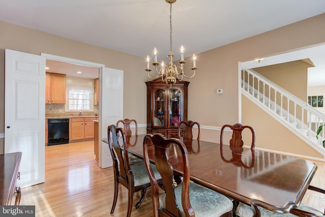 dining room with light hardwood / wood-style flooring, sink, and a chandelier