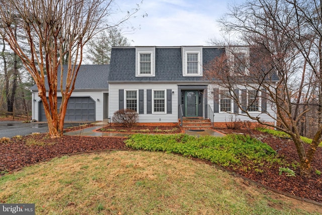 view of front of house with a garage, driveway, and roof with shingles