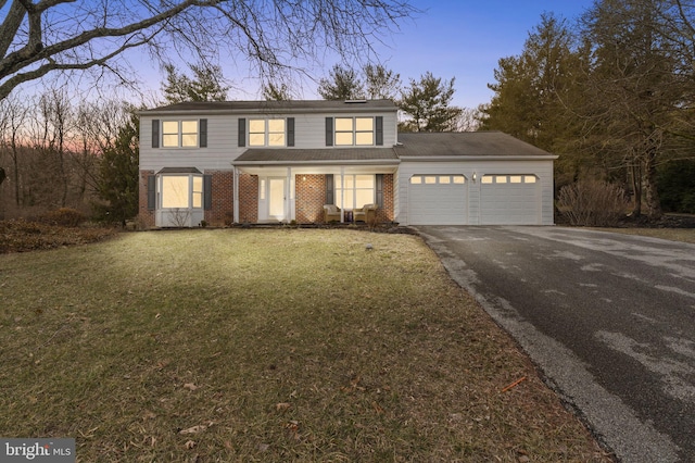 view of front of property with a garage and a lawn