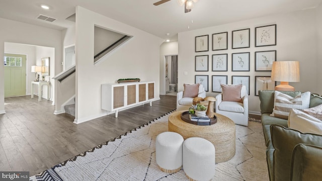 living room featuring dark wood-type flooring and ceiling fan