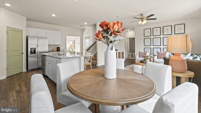 dining area featuring dark wood-type flooring, ceiling fan, and sink