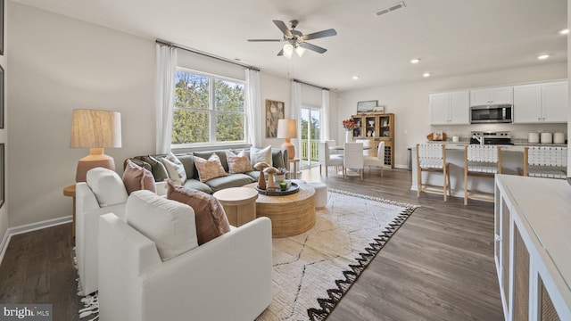 living room with dark hardwood / wood-style floors and ceiling fan