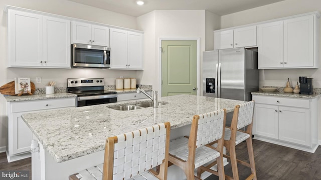 kitchen with a kitchen island with sink, appliances with stainless steel finishes, sink, and white cabinets