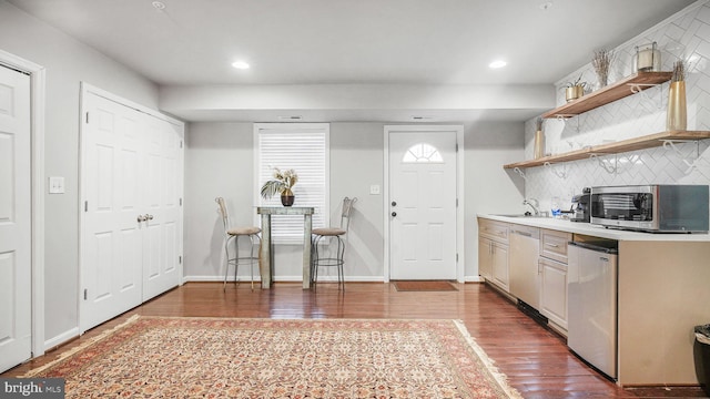 kitchen featuring refrigerator, open shelves, stainless steel microwave, backsplash, and dishwashing machine