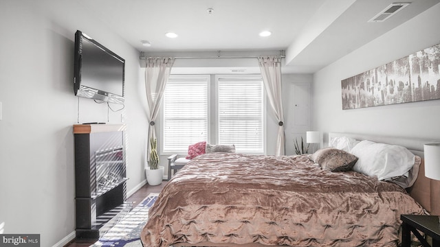 bedroom with recessed lighting, wood finished floors, visible vents, and baseboards