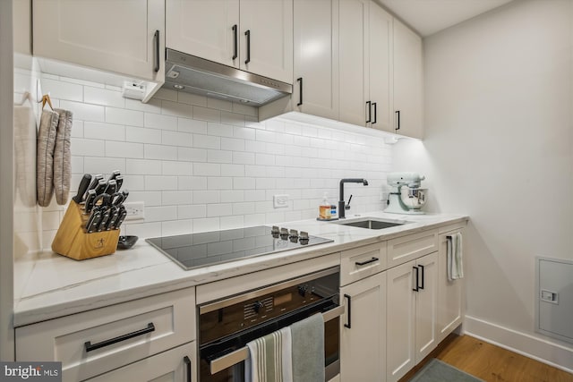 kitchen with white cabinetry, light stone countertops, sink, and black appliances