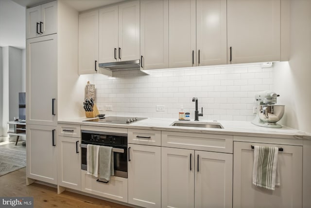 kitchen with sink, white cabinetry, stainless steel oven, black electric stovetop, and hardwood / wood-style floors