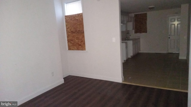 empty room with dark wood-type flooring and sink