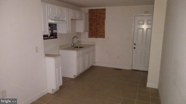 kitchen with white cabinetry, sink, and tile patterned floors