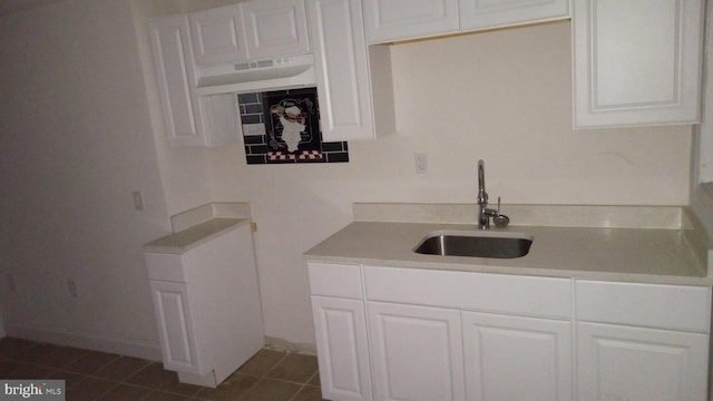 kitchen featuring white cabinetry, sink, and dark tile patterned flooring