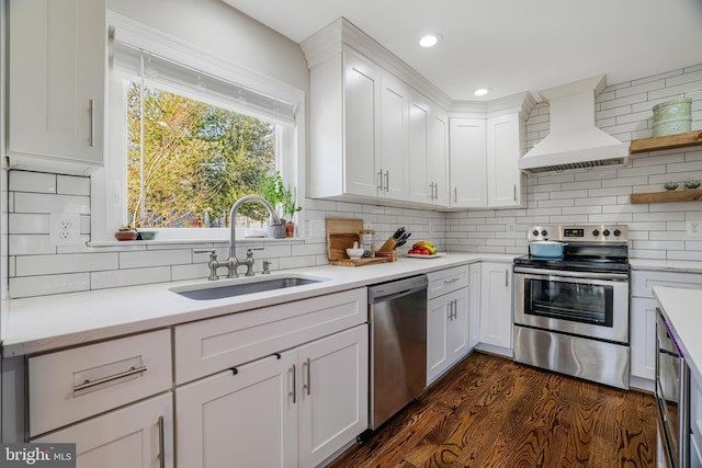 kitchen with appliances with stainless steel finishes, sink, custom exhaust hood, and white cabinets