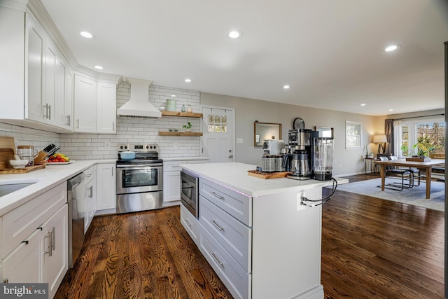 kitchen with white cabinetry, appliances with stainless steel finishes, dark hardwood / wood-style flooring, and premium range hood