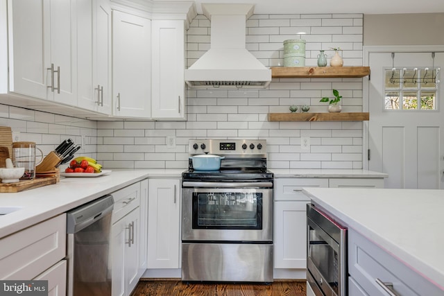 kitchen featuring white cabinets, appliances with stainless steel finishes, custom exhaust hood, and decorative backsplash