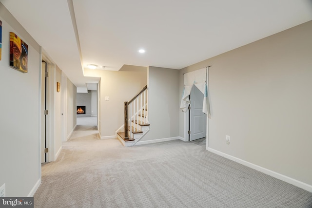 carpeted empty room featuring a large fireplace