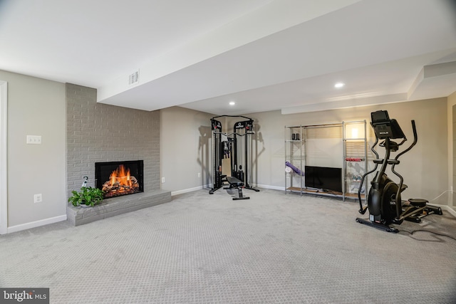 exercise area with carpet floors and a fireplace