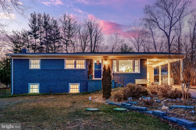 view of front of home featuring a yard and a carport